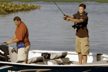 a man standing next to a body of water