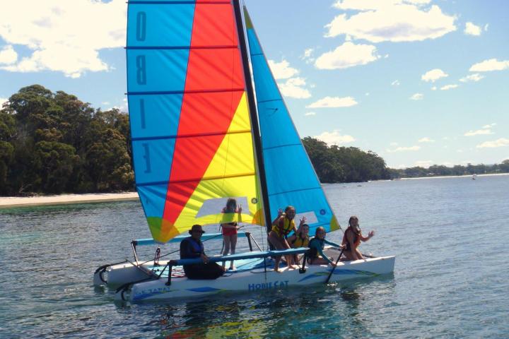 a group of people riding on the back of a boat in the water