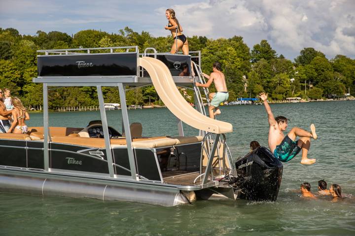 a group of people riding on the back of a boat in the water